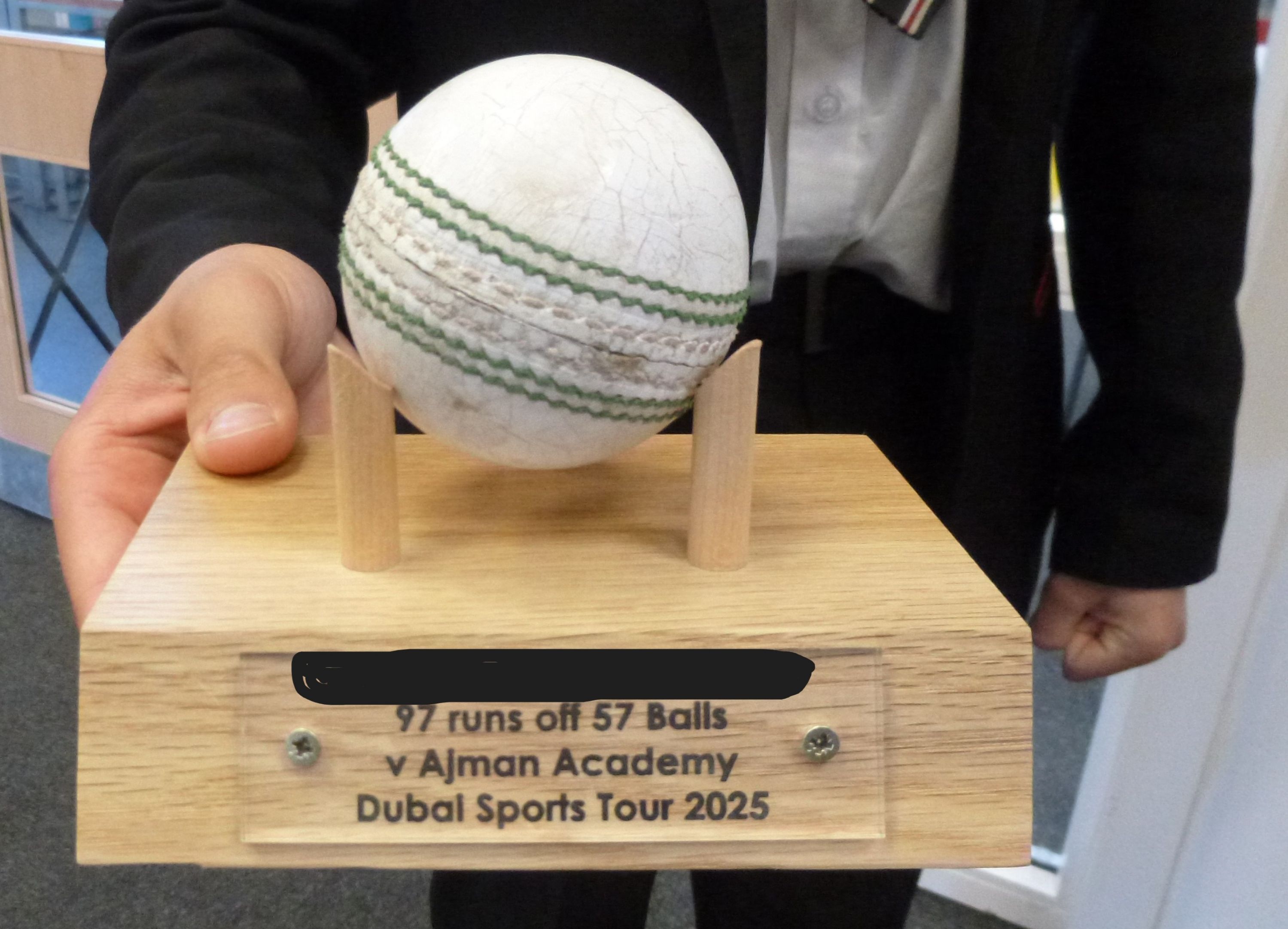 student holding the cricket ball trophy